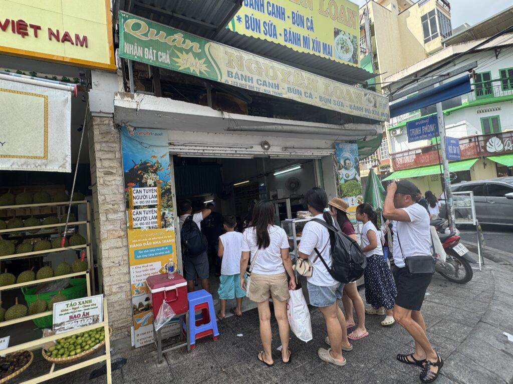 Front view of Quán Nguyễn Loan with local customers lining up outside