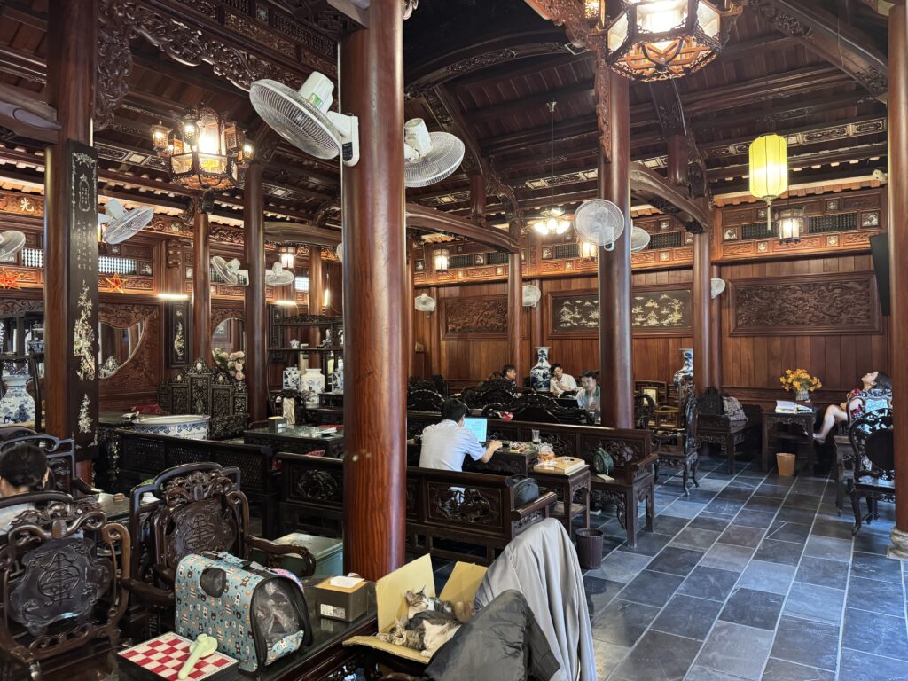 Traditional Vietnamese wooden cafe interior with carved furniture and warm lighting in Hanoi