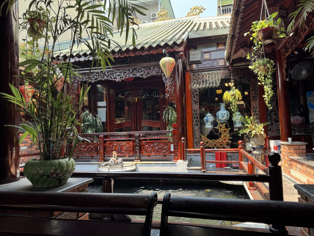 Wooden Vietnamese cafe courtyard with traditional decor and natural sunlight