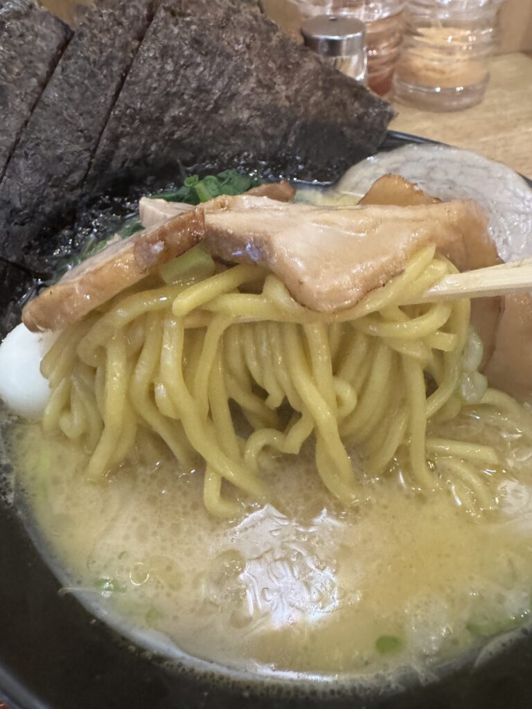 Thick noodles and chashu lifted from a bowl of Iekei ramen at Tatsuichiya in Hanoi