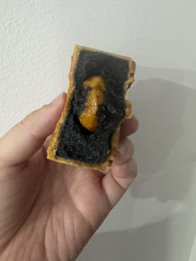 Cut JW Marriott Hanoi mooncake with dark filling and an egg yolk center